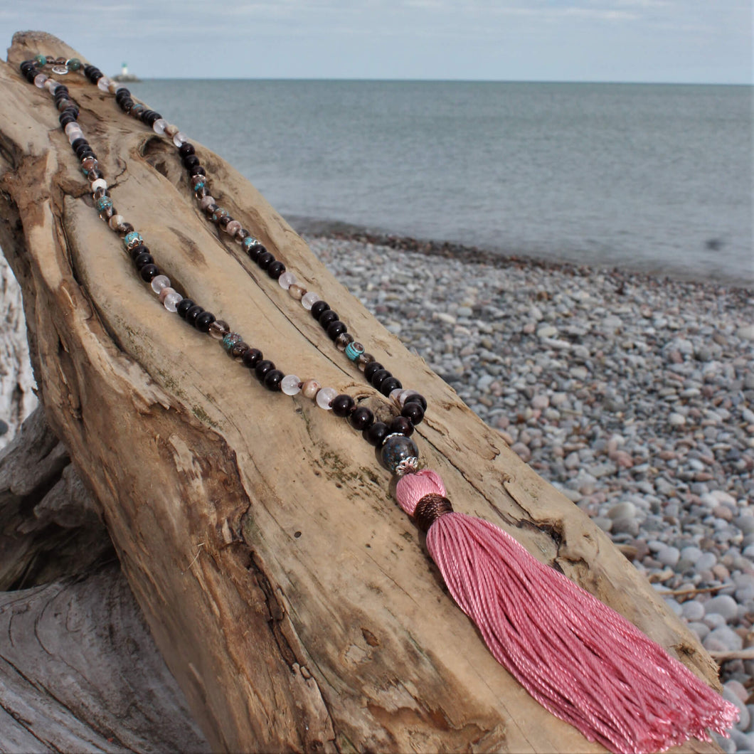 Always Surrounded Crystal Mala wil pink tassle on beach